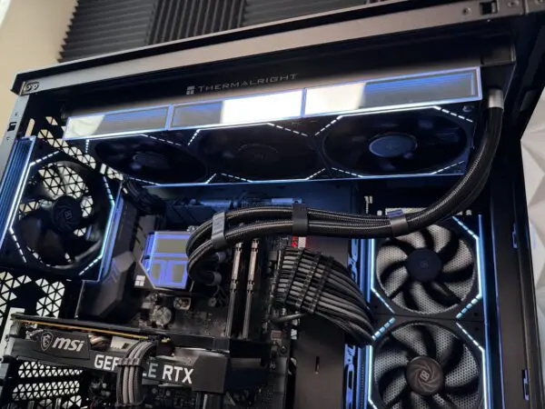 Close-up of the DKBPC Core PC highlighting the Thermalright liquid cooler, RGB fans, sleeved cables, and custom-built gaming hardware.